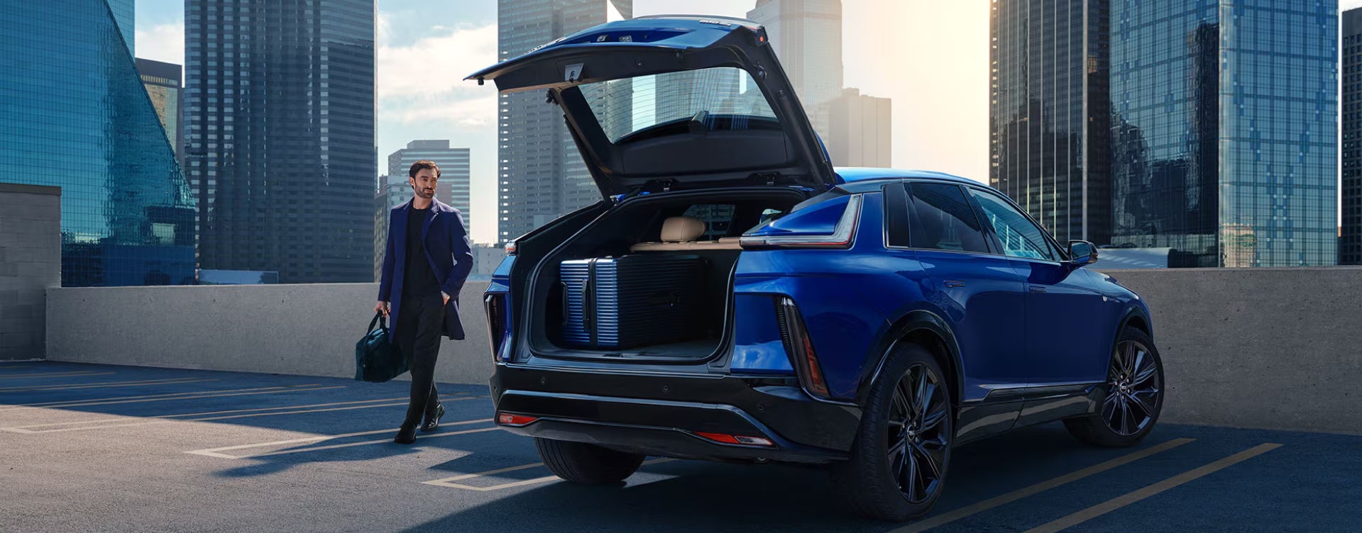 Man walking to an open trunk of his Cadillac SUV